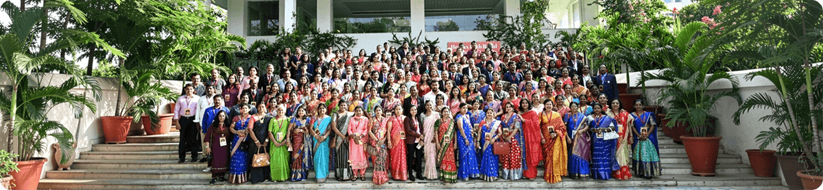 Group of people in formal attire posing for a photo on steps outdoors.