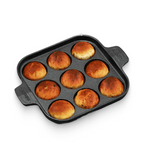 Baked buns in a square baking pan on a white background