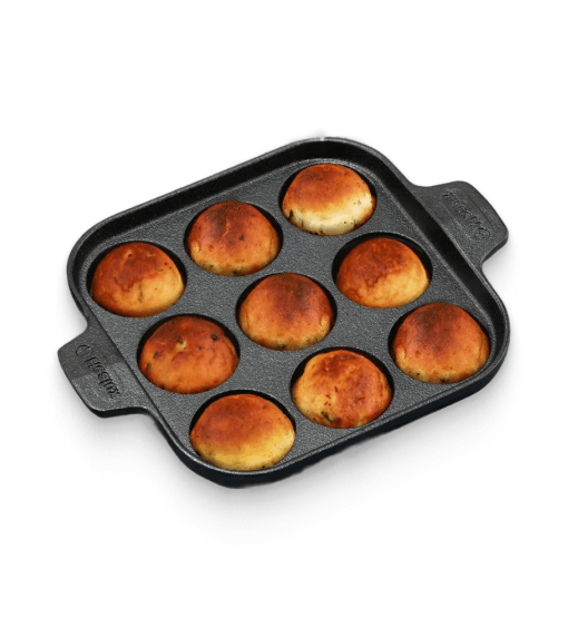 Baked buns in a square baking pan on a white background