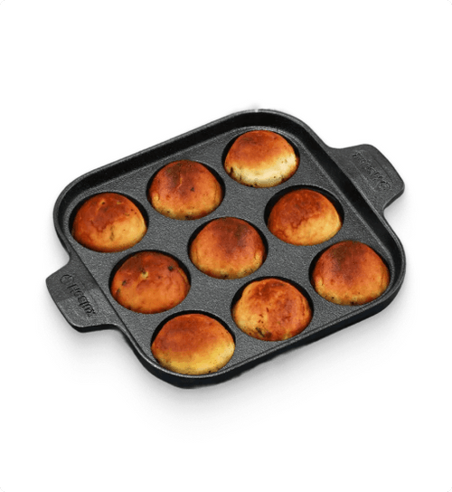 Baked buns in a square baking pan on a white background