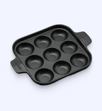 Black muffin tin with multiple compartments on a white background