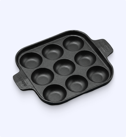 Black muffin tin with multiple compartments on a white background