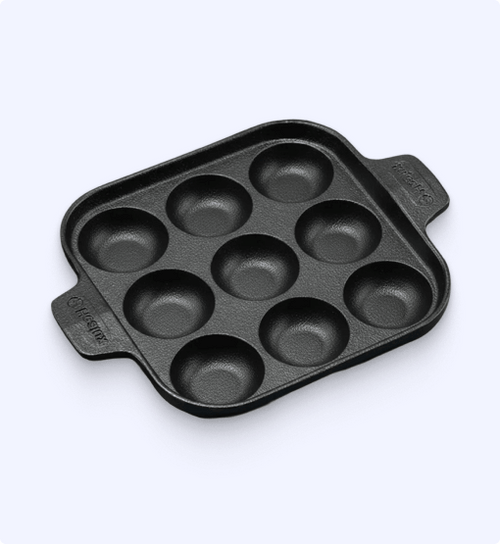 Black muffin tin with multiple compartments on a white background