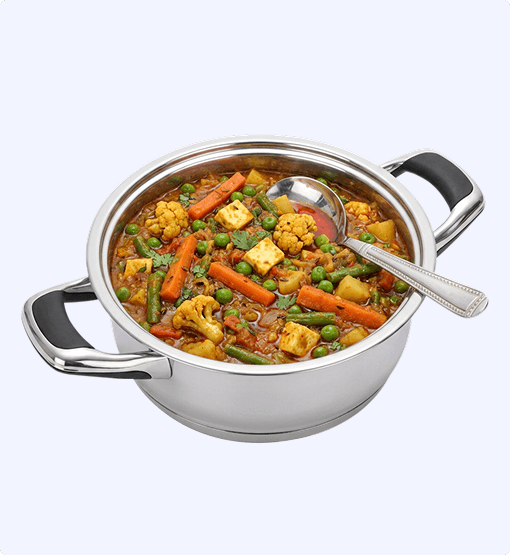 Stainless steel pot with vegetable curry and a spoon on a white background