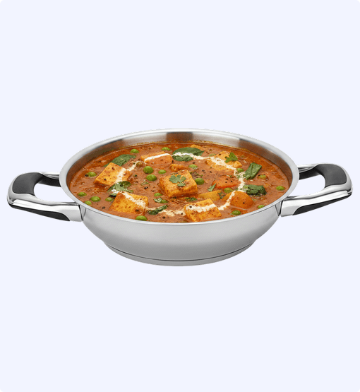 Stainless steel kadai with paneer butter masala on a white background