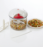 Vegetable chopper with chopped vegetables on a white surface