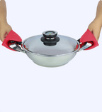 Person holding a silver wok with a lid using red oven mitts on a white background