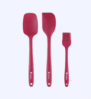Set of three red silicone kitchen utensils on a white background