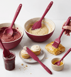 Pink silicone spatulas used in various baking tasks on a white surface