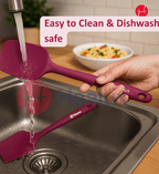 Purple spatula being rinsed under running water in a kitchen sink with a bowl of food in the background.