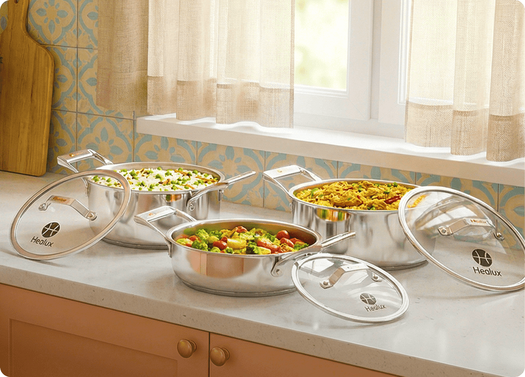 Set of stainless steel cookware with lids on a kitchen counter
